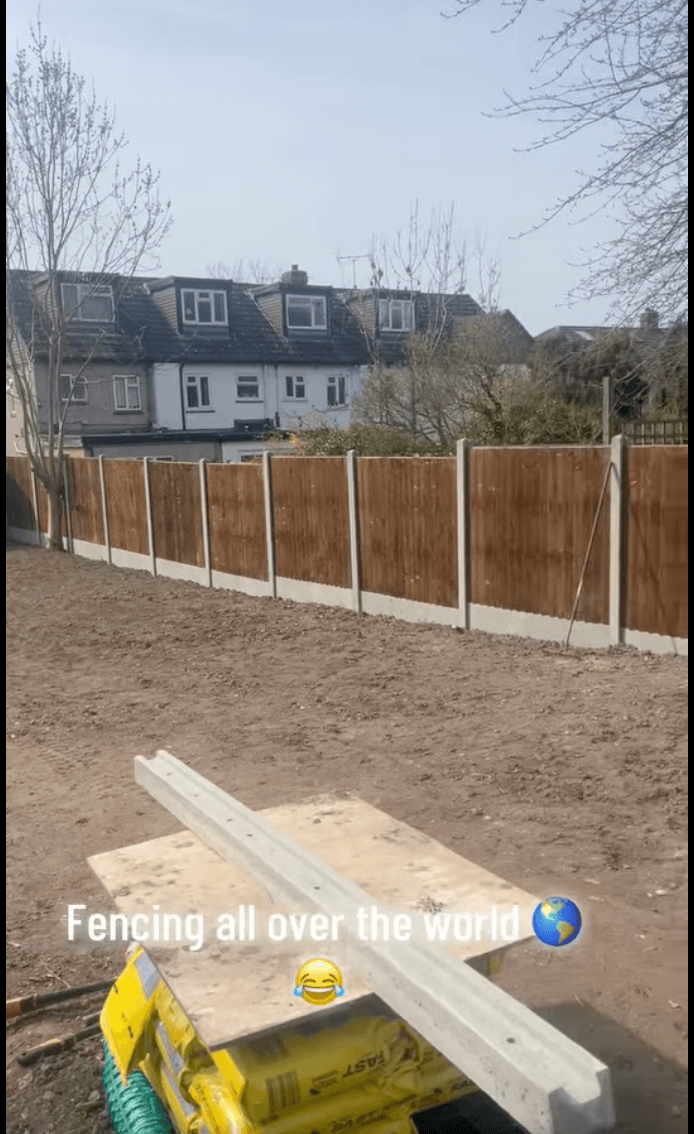 Newly installed run of timber fencing in front of a row of houses — captioned 'Fencing all over the world'.