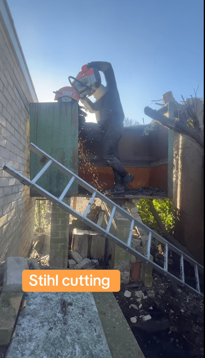 Operator on a ladder using a Stihl chainsaw to cut into a structure — captioned 'Stihl cutting'.
