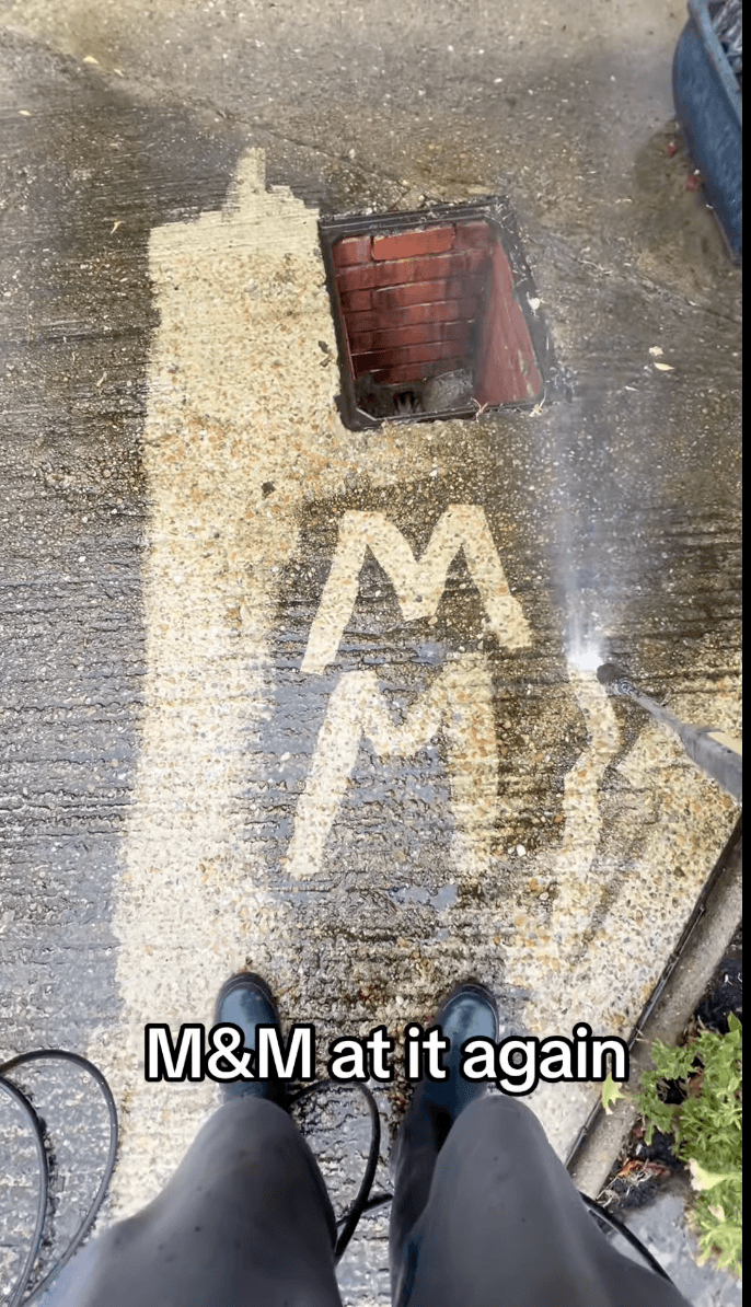 Freshly screeded sand bedding with 'M&M' written in the sand by hand — captioned 'M&M at it again'.
