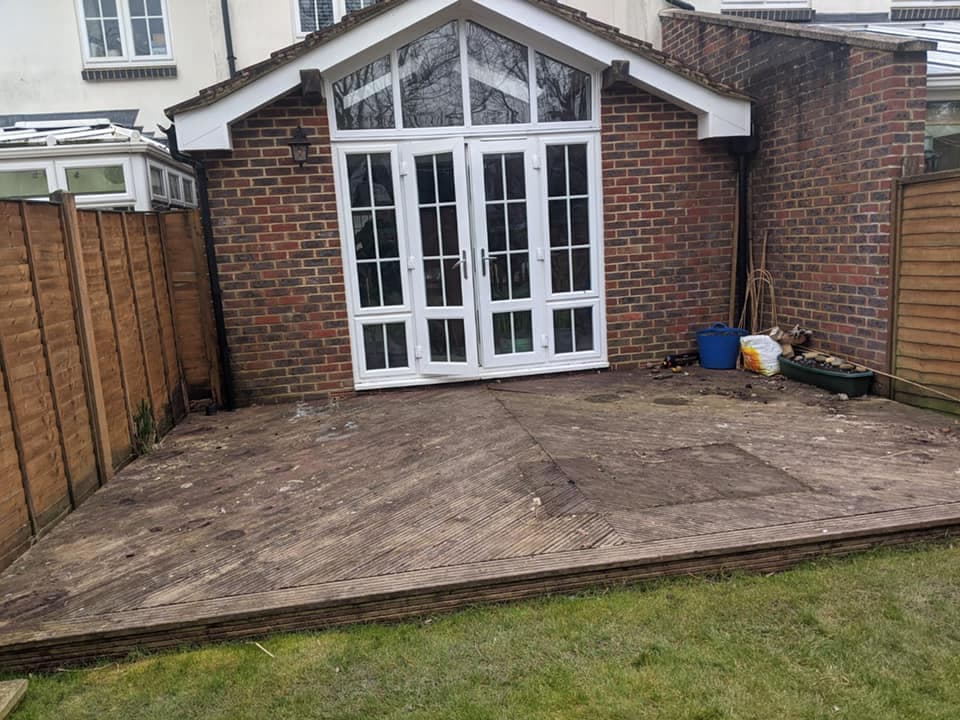 Before — old rotting wooden decking and tatty brown fencing at the same property