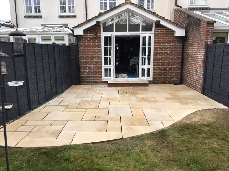 After — new Indian sandstone patio and fresh dark fencing in Oxted, Kent